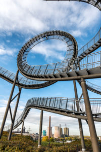 Duisburg, Nordrhein-Westfalen, Deutschland, Landmarke Tiger & Turtle - Magic Mountain im Hintergrund das Gaskraftwerk Duisburg-Huckingen im Stadtteil Hüttenheim. Duisburg, Nordrhein-Westfalen, Deutschland, Landmarke Tiger & Turtle - Magic Mountain im Hintergrund das Gaskraftwerk Duisburg-Huckingen im Stadtteil Hüttenheim.