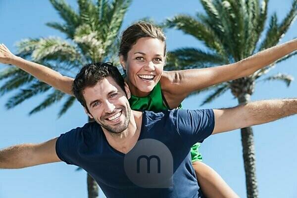 Man giving and adult woman a piggyback ride laughing and having fun in San  Diego, California. Stock Photo