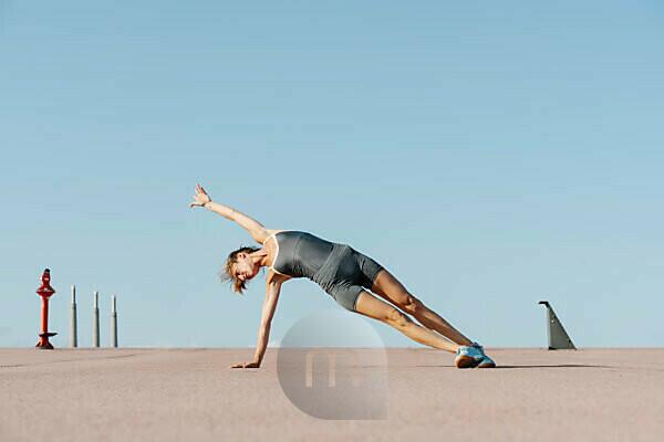 Young Sportswoman Doing Warm-up Balance Exercise Standing On One