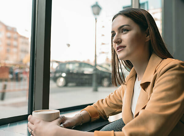 Smiling woman with coffee cup sitting on jetty stock photo