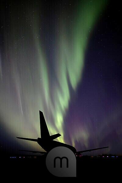 Bildagentur mauritius images Silhouetted airplane with Aurora