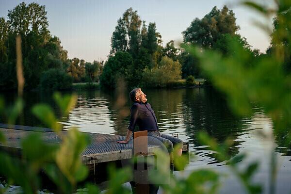 Boy fishing in a lake with a bow and arrow, Lago Miwa, as