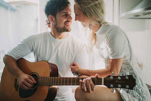 Young couple in love making music at home, half portrait