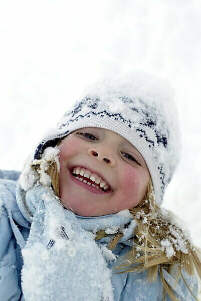 Two little kid boys in colorful fashion clothes playing outdoors during  strong snowfall. Active leisure with children in winter on cold days. Happy  siblings and twins having fun with first snow. Stock