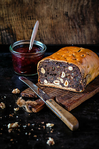 South Tyrolean fruit loaf on an old wooden board, parts of it already cut off 