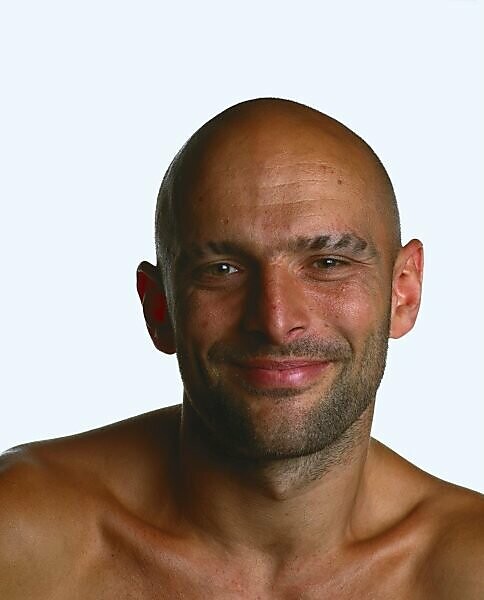 Confident caucasian man standing in a studio, with a look of self-assurance  on his face. Young man with perfect skin and facial hair embraces his  beauty and masculine appearance. stock photo