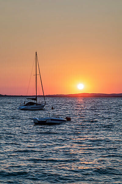 small boat moored in front of the beach of vrsi mulo at sunset, vrsi, zadar county, dalmatia, croatia