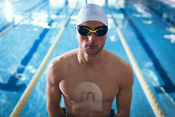 Male swimmer wearing a swimming hat at the pool