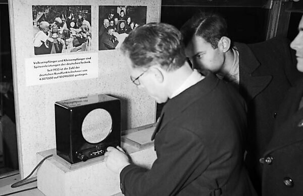 Visitors walking through the exhibition of the "Sonderfahrt der deutschen Technik" propaganda exhibition, here the Volksempfänger radio, Germany 1930s.