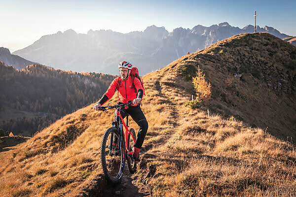 A man rides an ebike MTB on the tracks in the San Nicolò valley, Fassa valley, Trentino, Dolomites, Italy