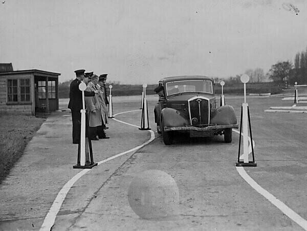 Training speed corps to beat crime. With the object of smashing the gangs of motor bandits and securing greater road safety, the metropolitan police are training an army of motoring police. During the war the police Driving School closed down but now it has opened again and is in full swing. After five wees training, the men are turned out as fully qualified motoring police and can negotiate the most dangerous roads with impunity. Photo shows, demonsration in reversing a car at the Hendon Driving School. 29 January 1946